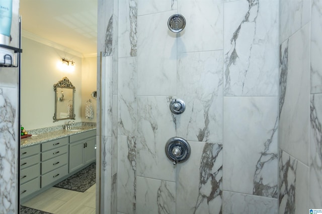 bathroom featuring tiled shower, vanity, and ornamental molding