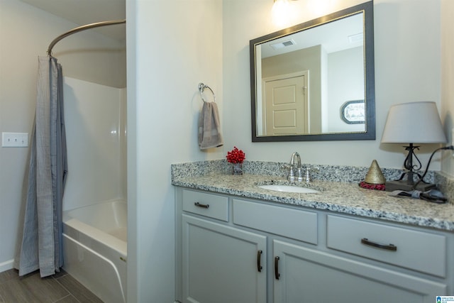 bathroom with hardwood / wood-style floors, vanity, and shower / tub combo with curtain