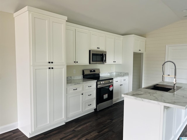 kitchen with sink, stainless steel appliances, light stone counters, vaulted ceiling, and white cabinets