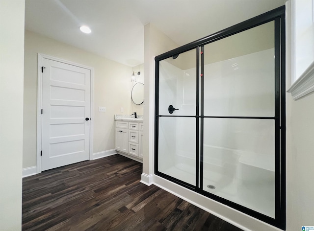 bathroom with walk in shower, vanity, and hardwood / wood-style flooring