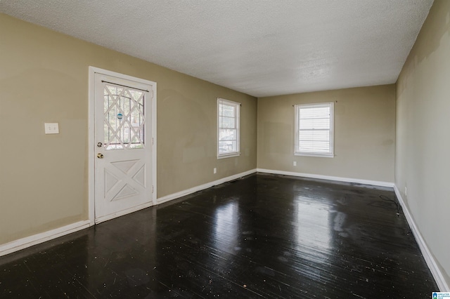 foyer with a textured ceiling and dark wood-type flooring