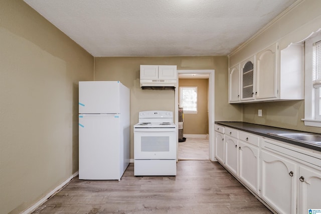 kitchen with white cabinetry, light wood-type flooring, white appliances, and a textured ceiling