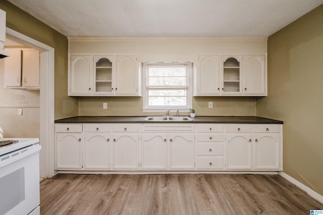 kitchen with electric range, sink, light hardwood / wood-style floors, a textured ceiling, and white cabinets