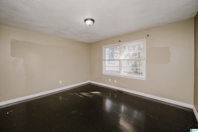 empty room with a textured ceiling and hardwood / wood-style flooring