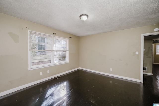 unfurnished room featuring dark hardwood / wood-style floors and a textured ceiling