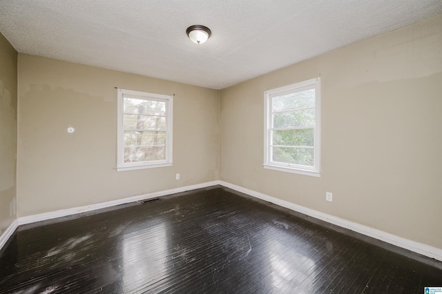 spare room with wood-type flooring and a textured ceiling