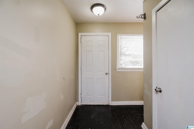 doorway to outside featuring a textured ceiling