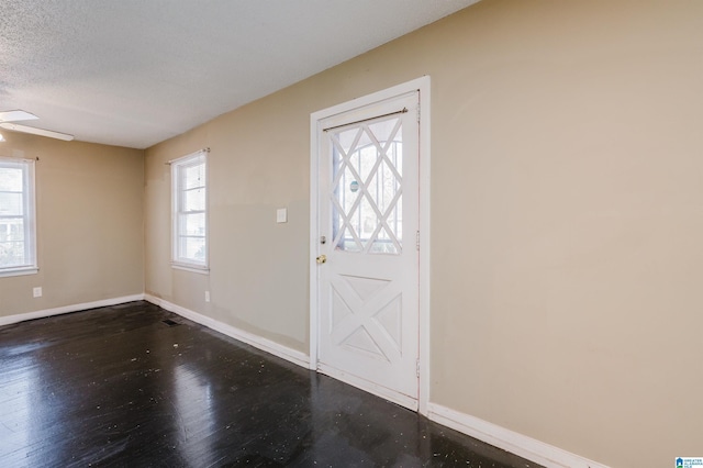 foyer featuring a textured ceiling, ceiling fan, and dark hardwood / wood-style floors