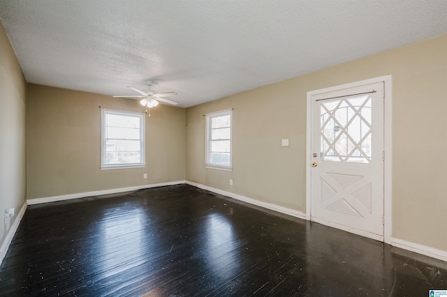 foyer entrance featuring ceiling fan, dark hardwood / wood-style flooring, and a textured ceiling