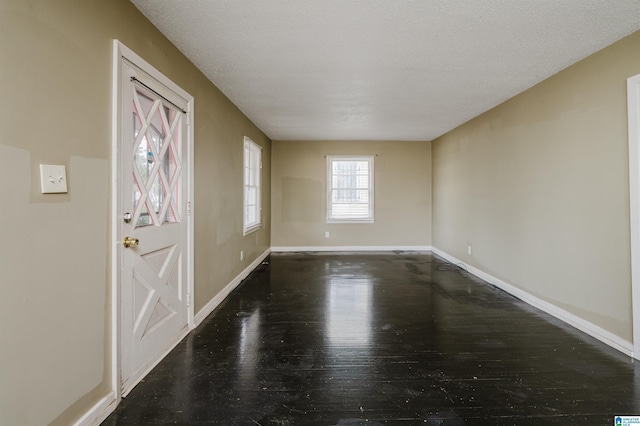 foyer entrance featuring dark hardwood / wood-style floors and a textured ceiling