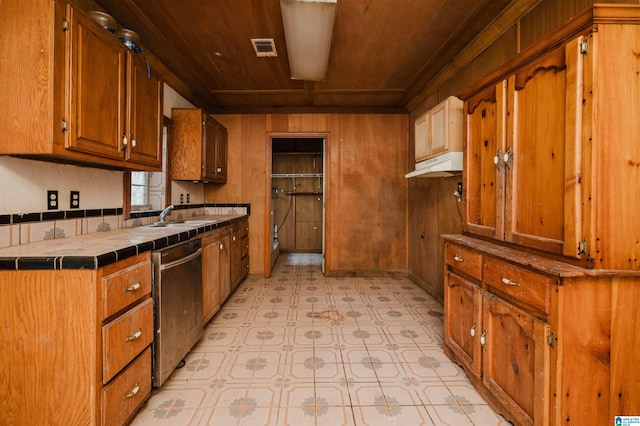 kitchen featuring stainless steel dishwasher, wood ceiling, sink, and tile countertops