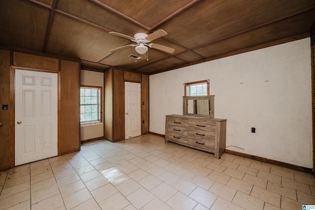 unfurnished bedroom featuring wooden walls, ceiling fan, wooden ceiling, and light tile patterned flooring