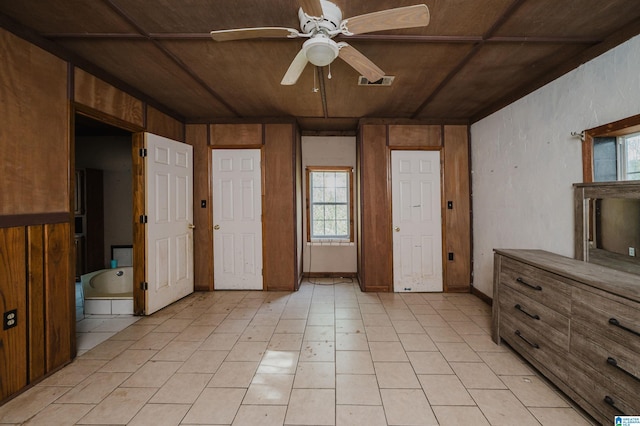 unfurnished bedroom with ensuite bath, wooden walls, and wooden ceiling