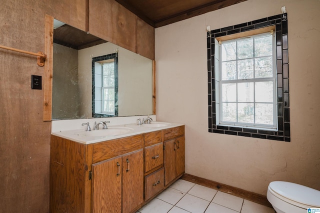 bathroom with toilet, vanity, and tile patterned floors