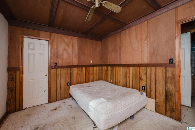 bedroom with light colored carpet, ceiling fan, and wooden walls