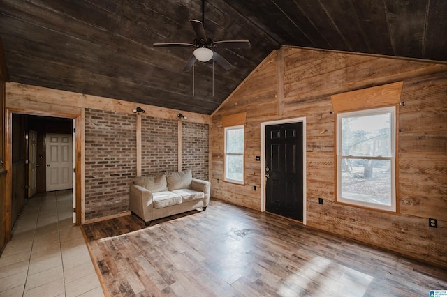 unfurnished room with light wood-type flooring, brick wall, ceiling fan, wooden walls, and wooden ceiling