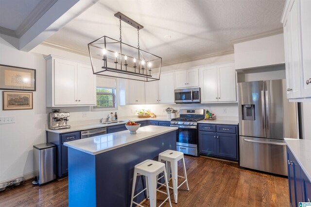 kitchen featuring appliances with stainless steel finishes, dark hardwood / wood-style flooring, white cabinetry, and a kitchen island