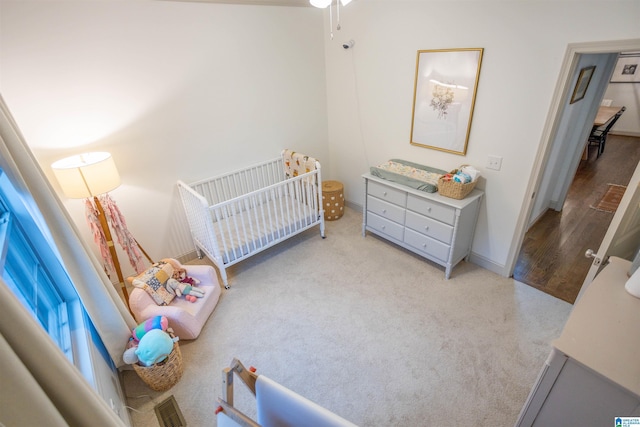 bedroom featuring light hardwood / wood-style flooring and a nursery area