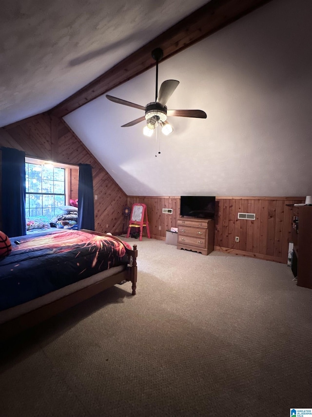 carpeted bedroom featuring lofted ceiling with beams, ceiling fan, and wooden walls