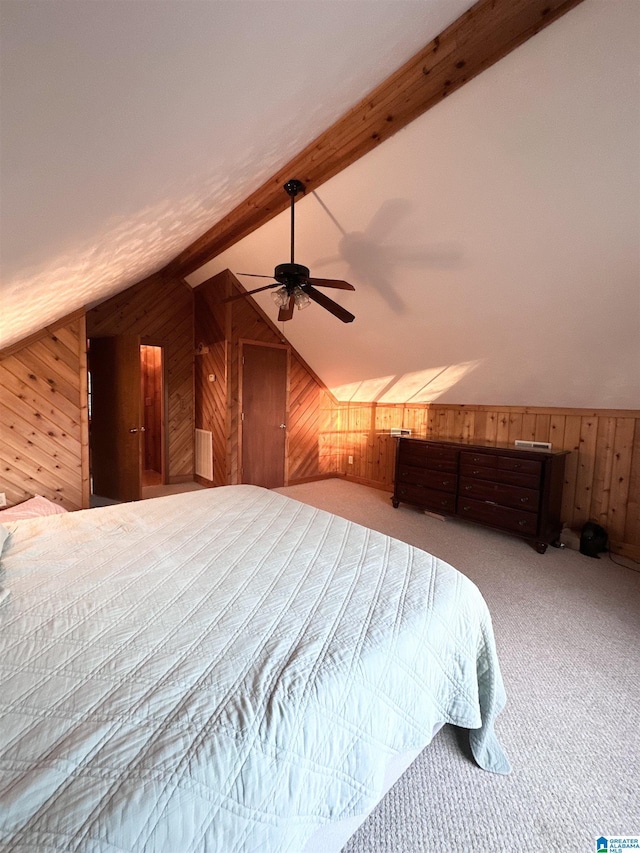 carpeted bedroom with ceiling fan, lofted ceiling with beams, and wood walls