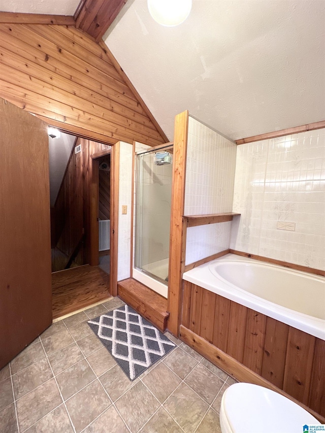 bathroom with shower with separate bathtub, wooden walls, tile patterned floors, and lofted ceiling