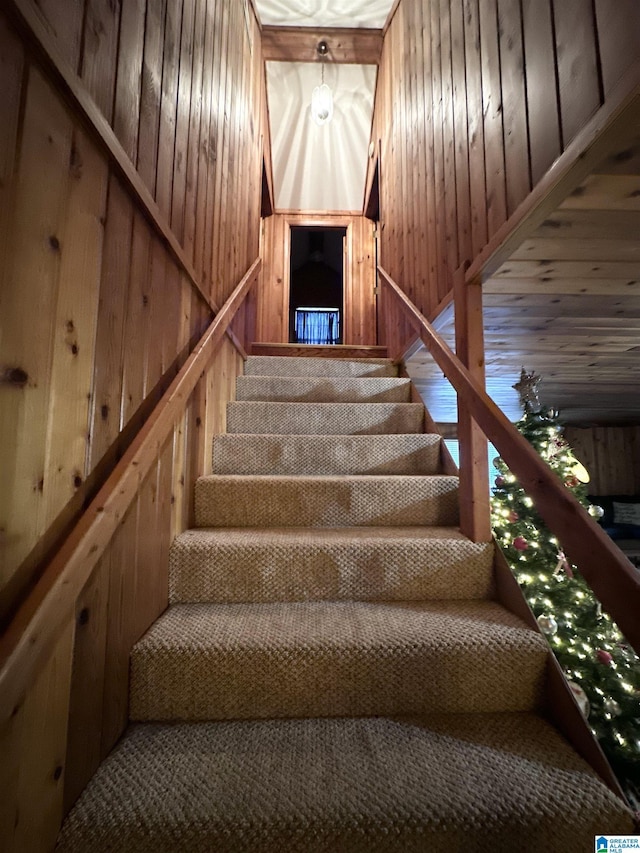 stairway featuring wood walls