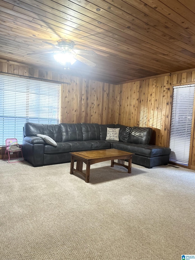 living room with carpet flooring, ceiling fan, wood walls, and wooden ceiling