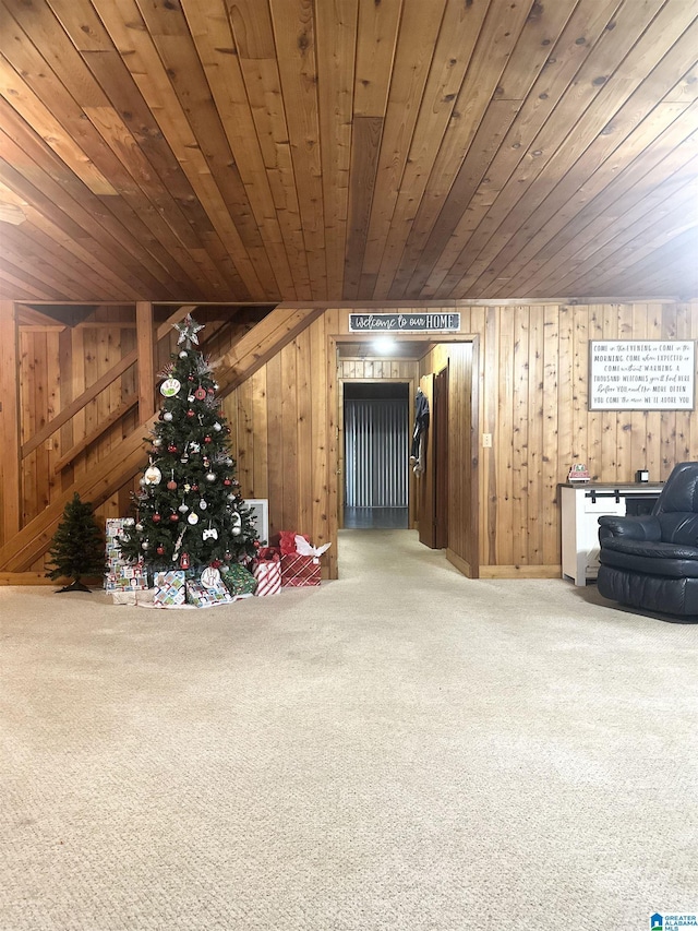 interior space with carpet flooring, wooden walls, and wood ceiling