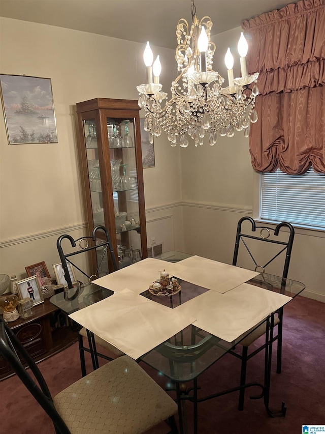 dining room with dark colored carpet and a chandelier