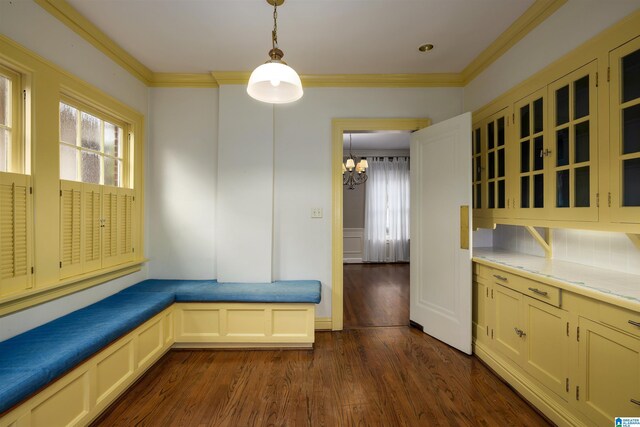 interior space featuring a chandelier, crown molding, and dark wood-type flooring