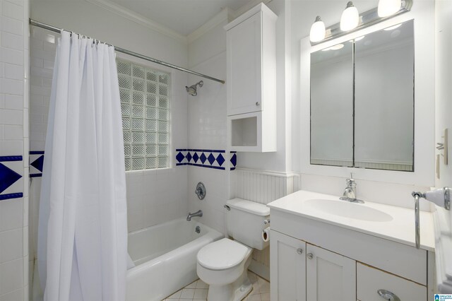 full bathroom with tile patterned floors, vanity, shower / bath combo with shower curtain, crown molding, and toilet