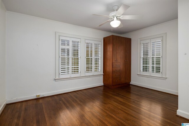 spare room featuring ceiling fan, dark hardwood / wood-style flooring, and crown molding