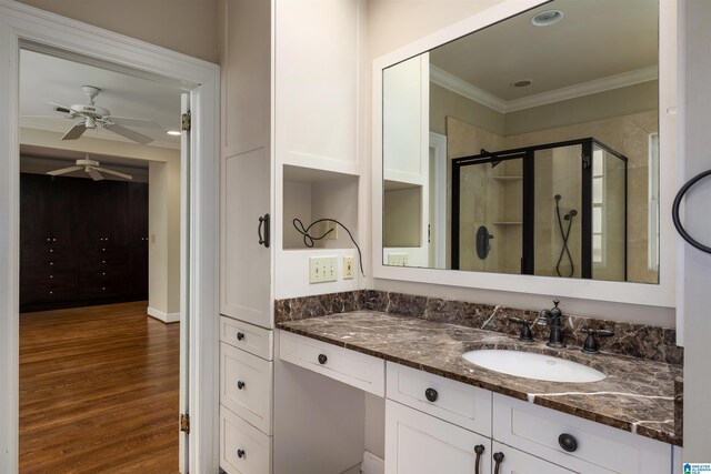 bathroom featuring an enclosed shower, vanity, ceiling fan, crown molding, and wood-type flooring