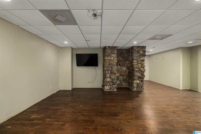 basement with wood-type flooring and a paneled ceiling