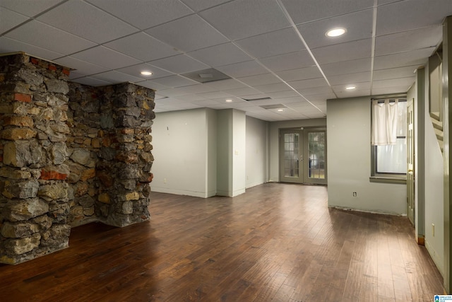 interior space with a paneled ceiling, dark hardwood / wood-style flooring, and french doors