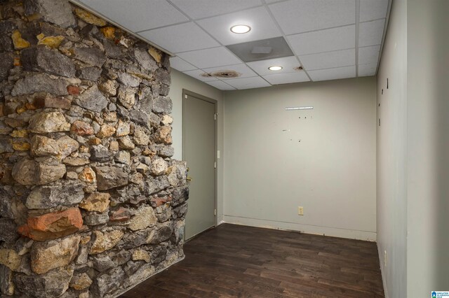 unfurnished room with a paneled ceiling and dark hardwood / wood-style floors