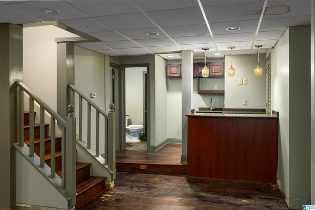 bar with a paneled ceiling, sink, dark hardwood / wood-style flooring, and hanging light fixtures