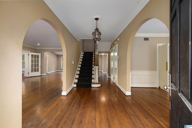 entrance foyer featuring crown molding and dark wood-type flooring