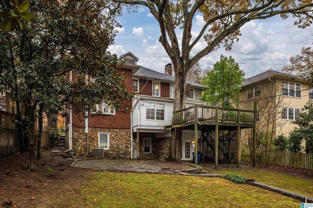 rear view of property featuring a patio, central AC, a lawn, and a wooden deck