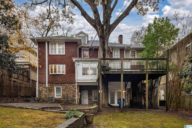 rear view of house featuring central air condition unit, french doors, a lawn, and a deck