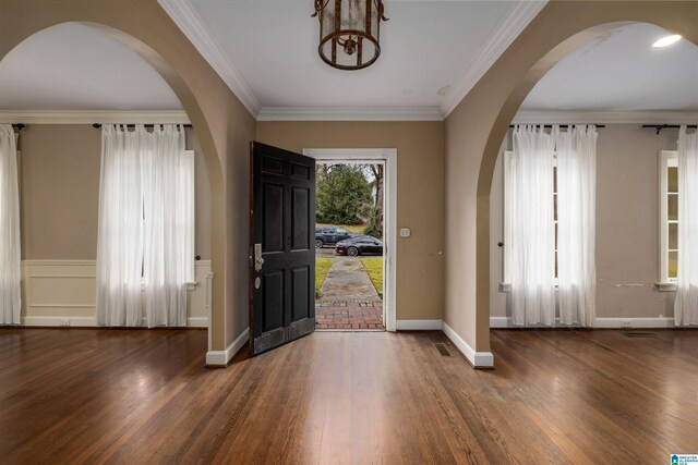 foyer entrance featuring crown molding and dark wood-type flooring