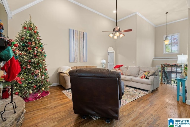 living room with hardwood / wood-style flooring, vaulted ceiling, ceiling fan, and crown molding