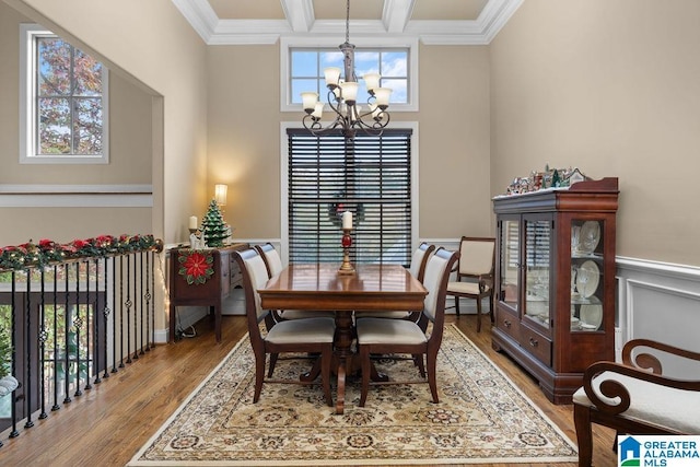 dining room with hardwood / wood-style flooring, a notable chandelier, crown molding, and beamed ceiling