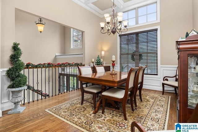 dining room featuring hardwood / wood-style floors, ornamental molding, and a chandelier