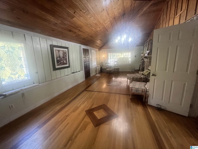 interior space featuring wood ceiling, wood-type flooring, a fireplace, a chandelier, and lofted ceiling