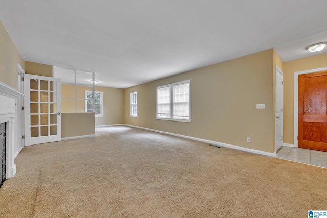 unfurnished living room featuring light carpet and plenty of natural light