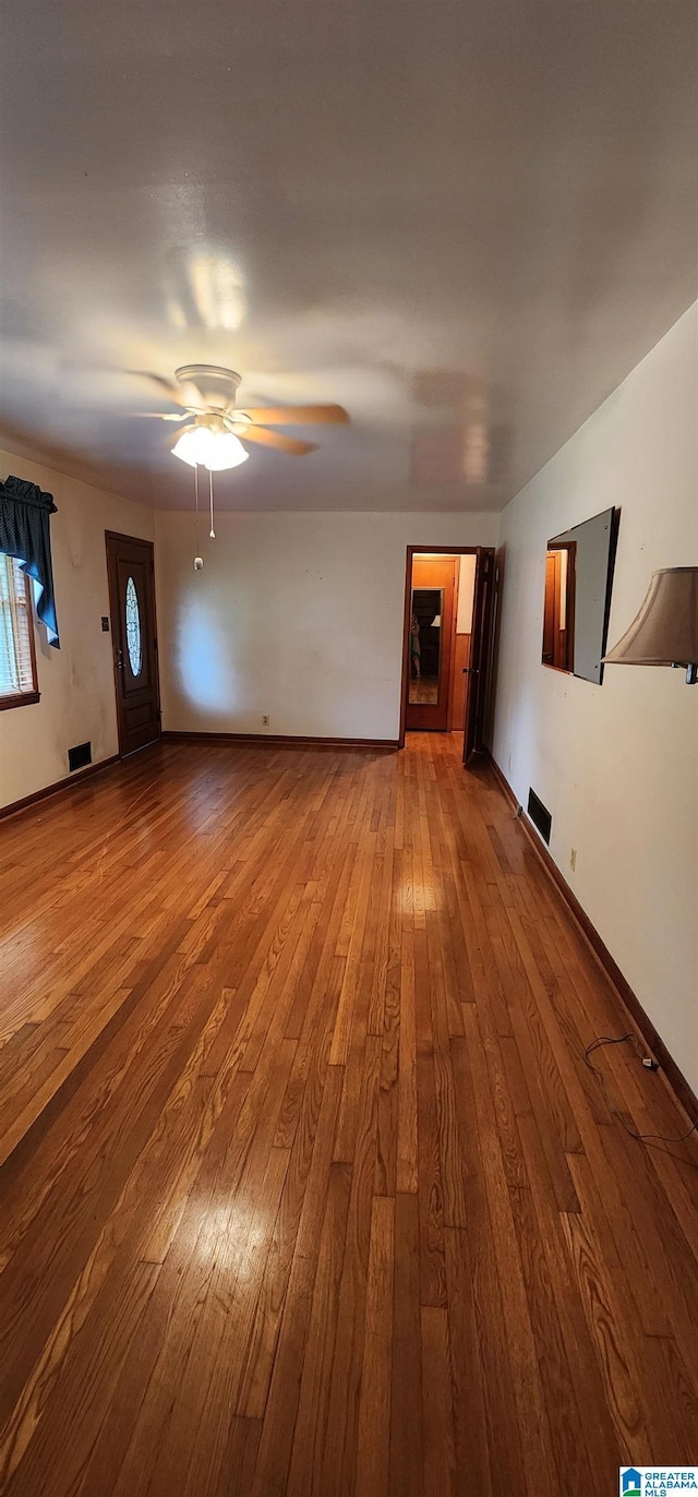 unfurnished living room featuring hardwood / wood-style flooring and ceiling fan