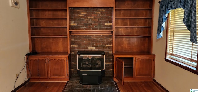 unfurnished living room with a wood stove and dark wood-type flooring