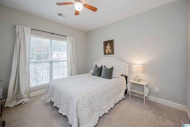 carpeted bedroom featuring multiple windows and ceiling fan