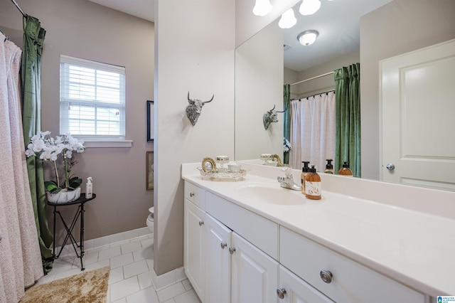 bathroom with tile patterned flooring, vanity, and toilet